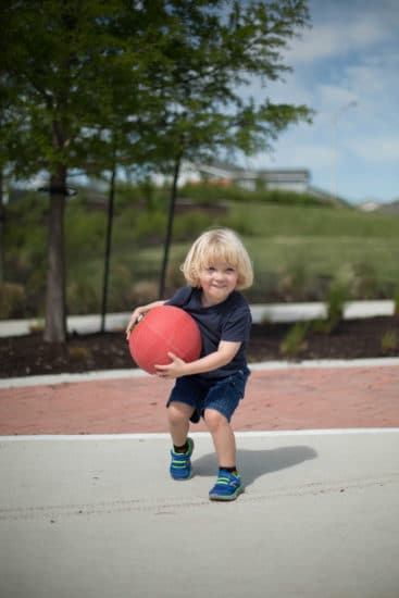 Young Kid With Big Basketball Ball