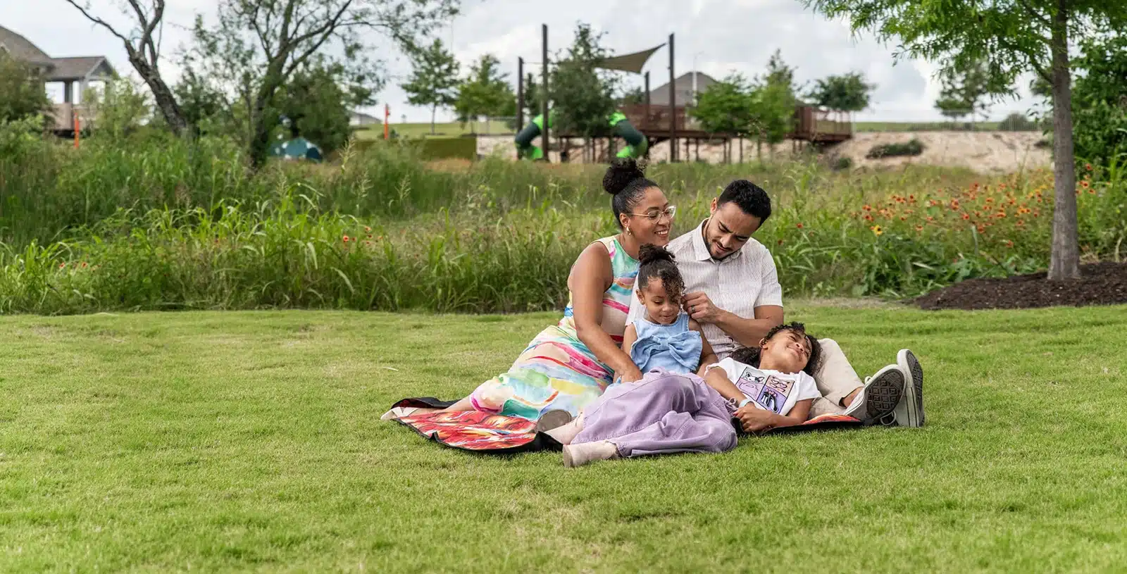 family sitting in park at Easton Park