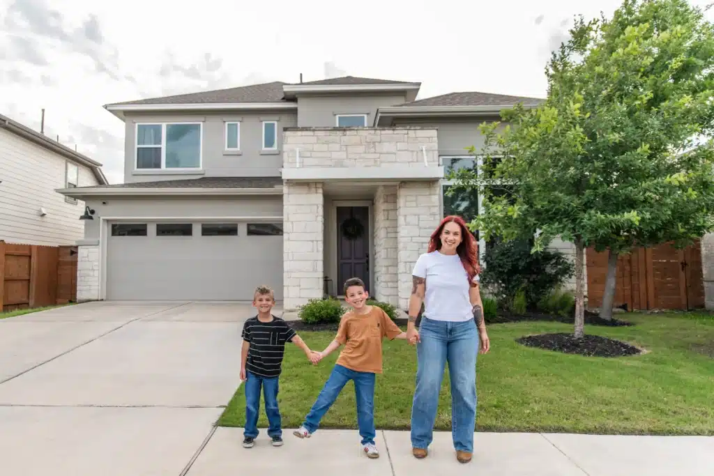 A young family in front of their new construction home in Easton Park.