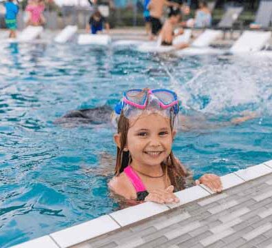 A child smiling in a pool